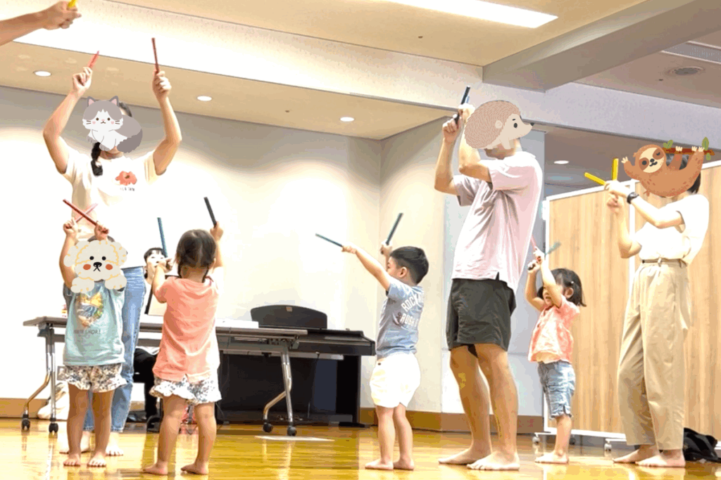 幼児がスティックを叩いている風景